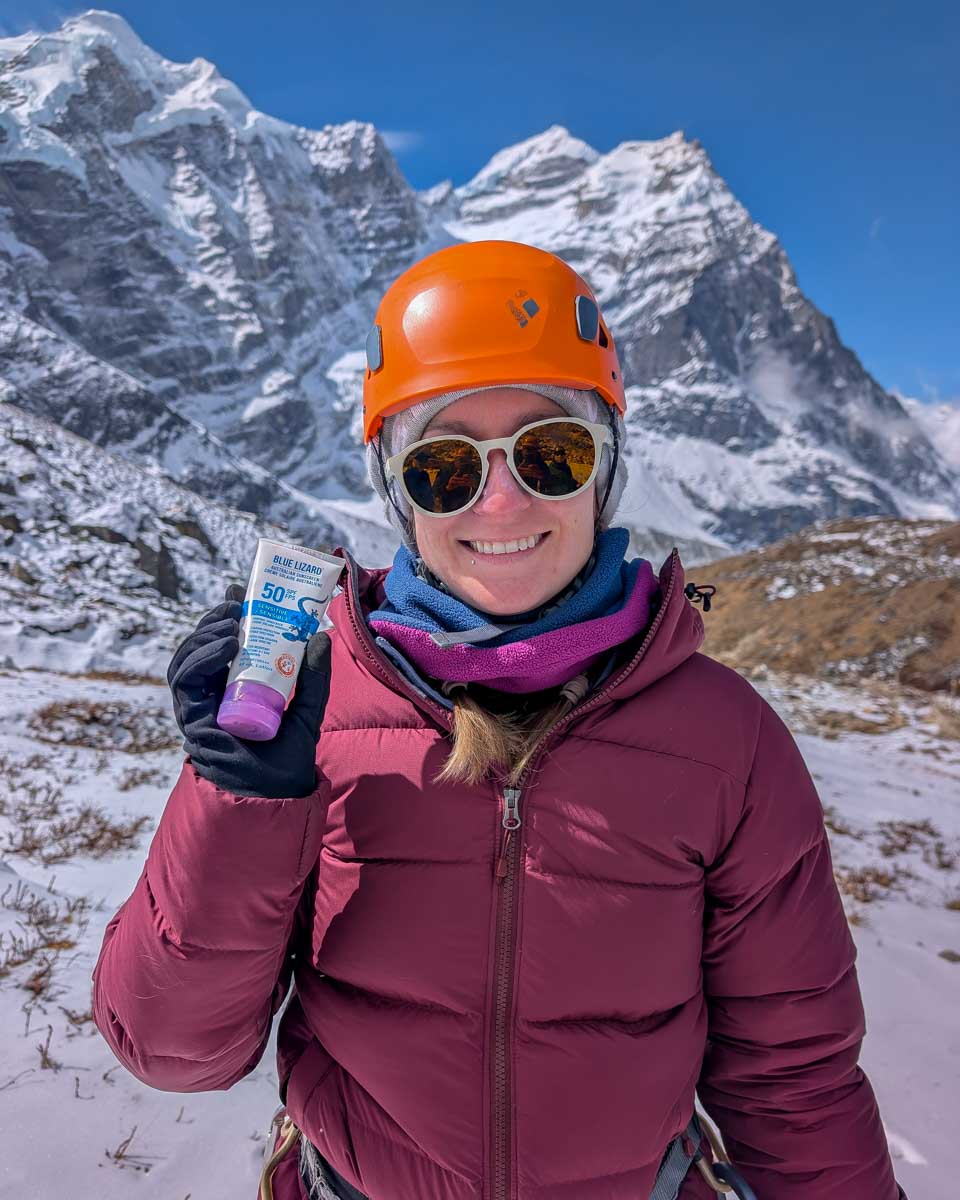 Bailey holds Blue Lizard sunscreen with mountain in the bakground