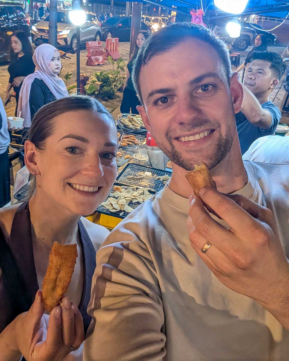 Daniel and Bailey eat snacks on a food tour in Kuala Lumpur Malaysia