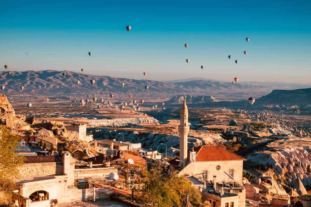 Balloons over Uchisar town in Cappadocia Turkey at sunrise