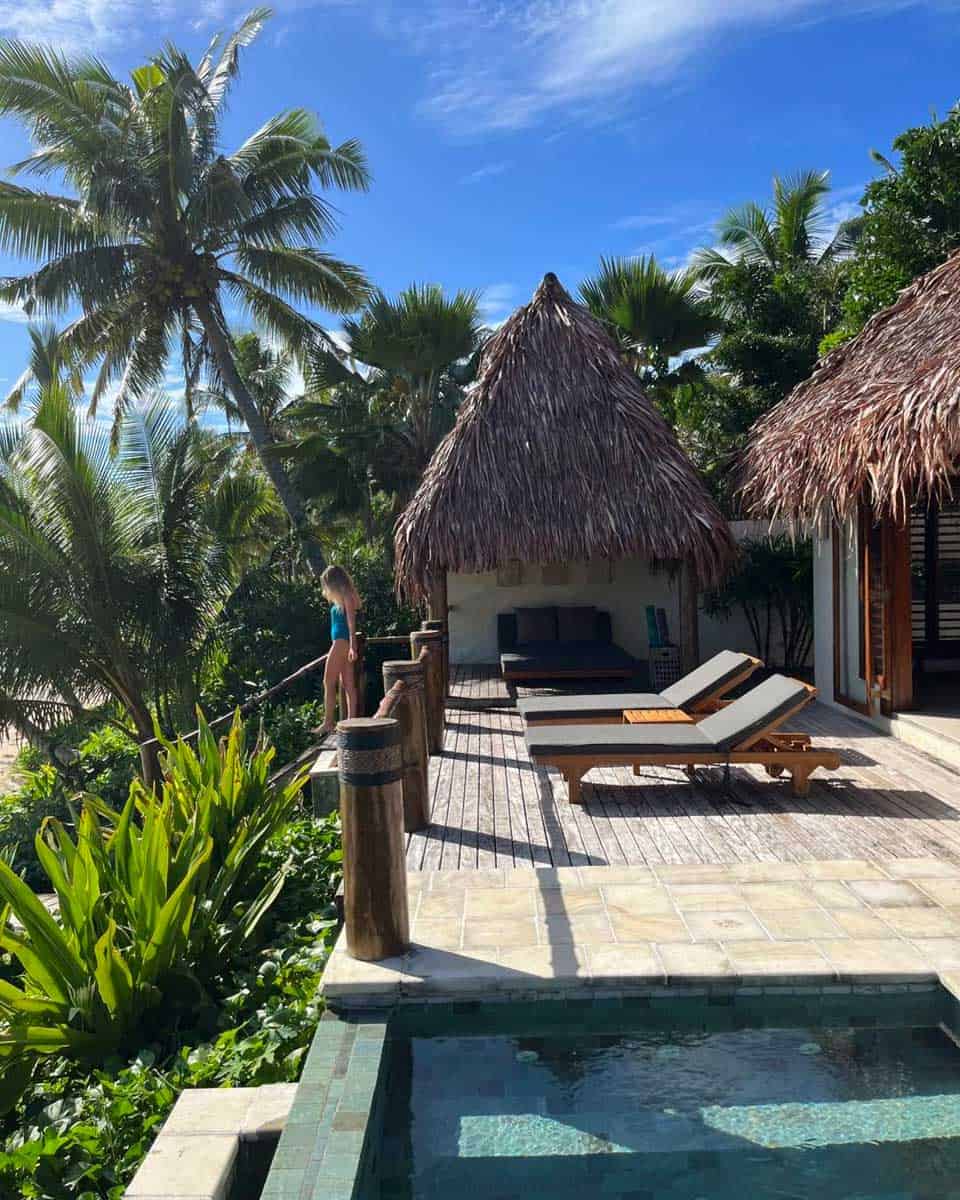A woman stand outside her room next to the pool at Tokoriki Island Resort Fiji