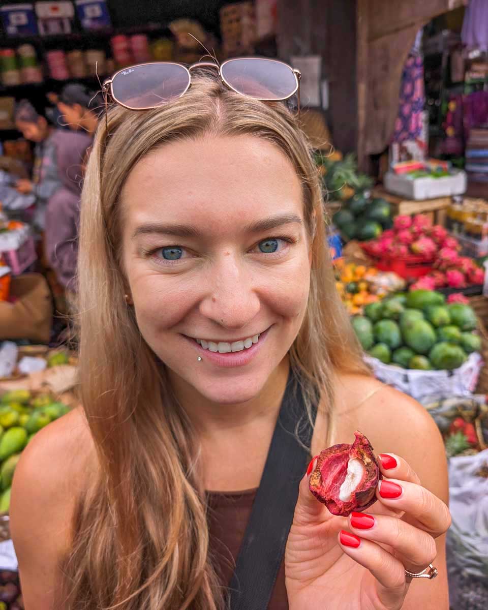 Bailey trying mangosteen at a market in Tahiti, French Polynesia