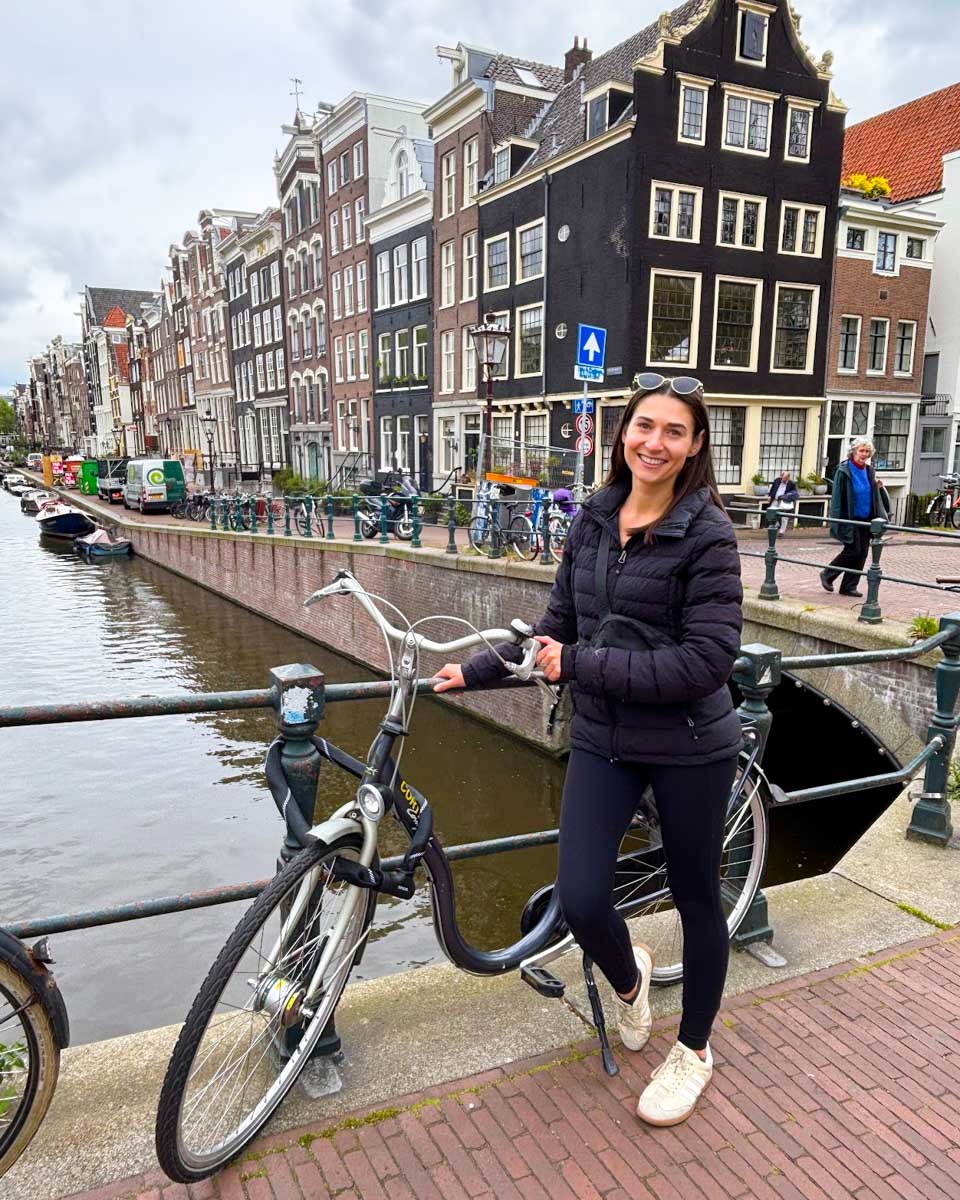 Brittni stands next to her bike while on a bike tour in Amsterdam