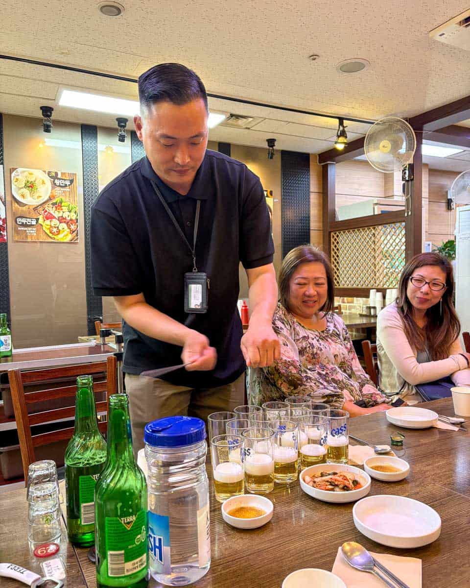 Guide on a food tour teaching us how to mix beer and soju in Seoul South Korea (1)