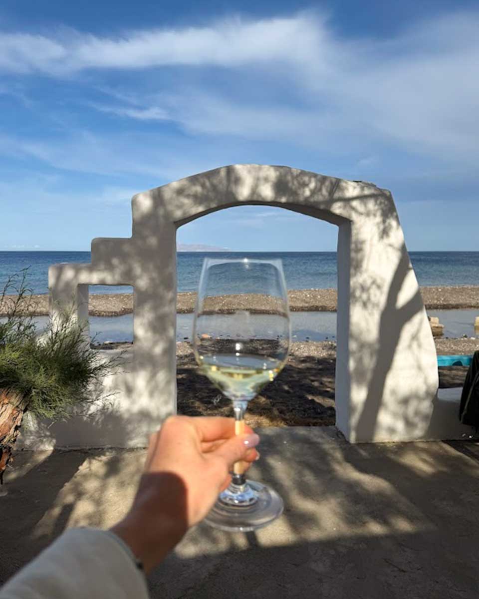 Hannah holding a wine glass at wine tasting in Santorini Greece
