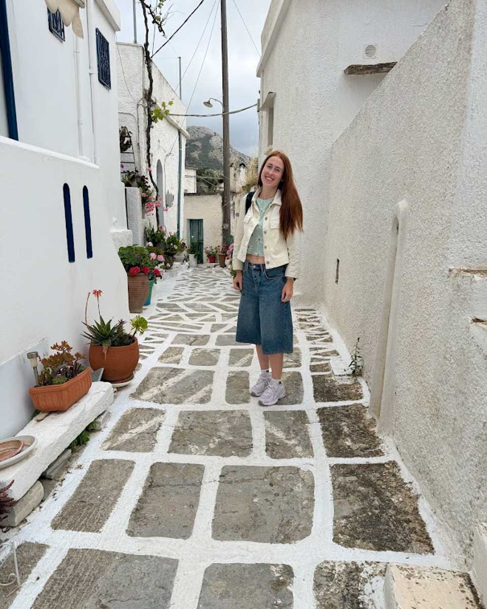 Hannah on the street between the whitewashed buildings of Naxos Greece