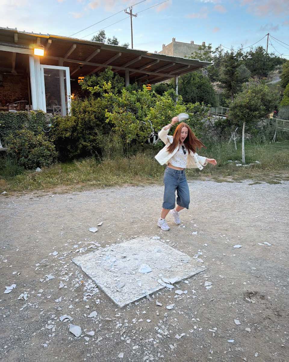 Hannah smashing plate in cooking class in Naxos Greece