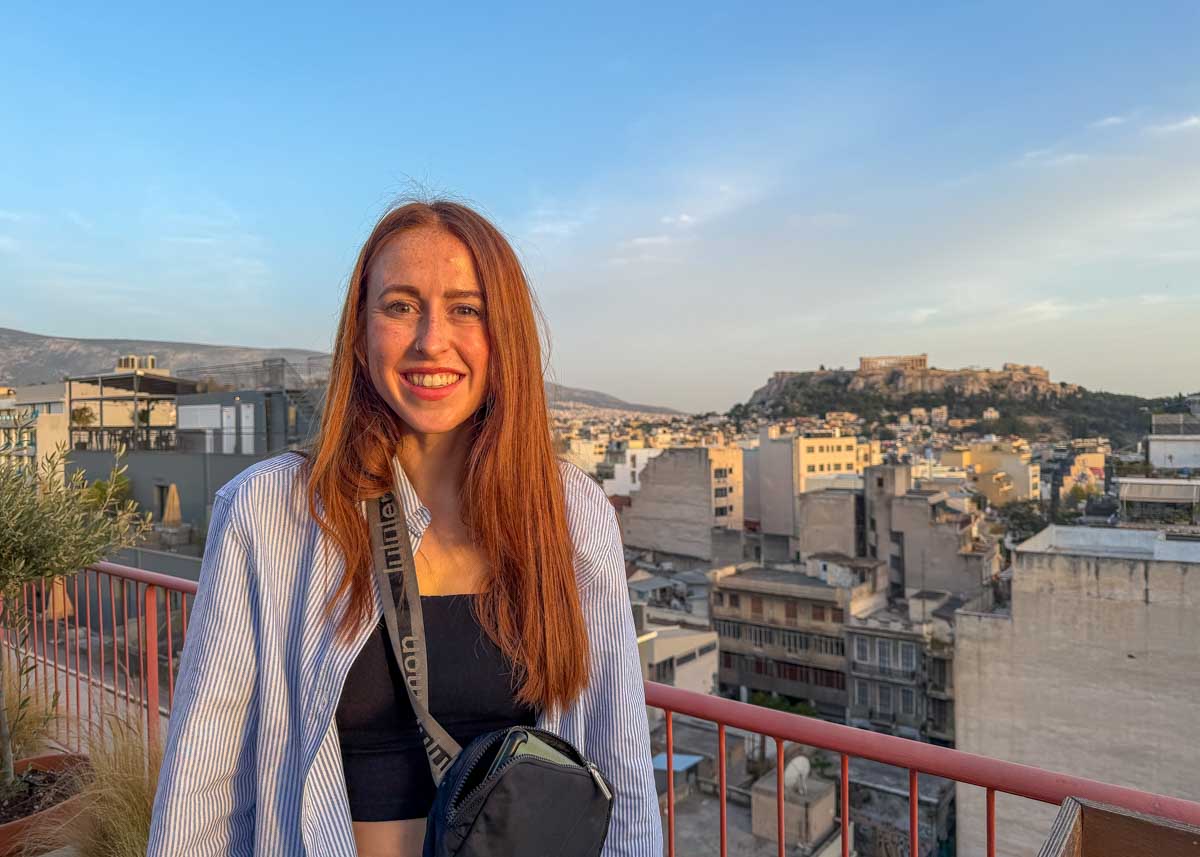 Hannah smiles at sunset with the Acropolis in the back in Athens Greece