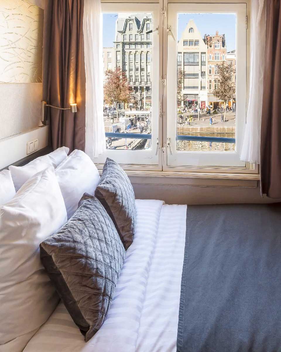 The bed next to the window with a view in Hotel CC Amsterdam