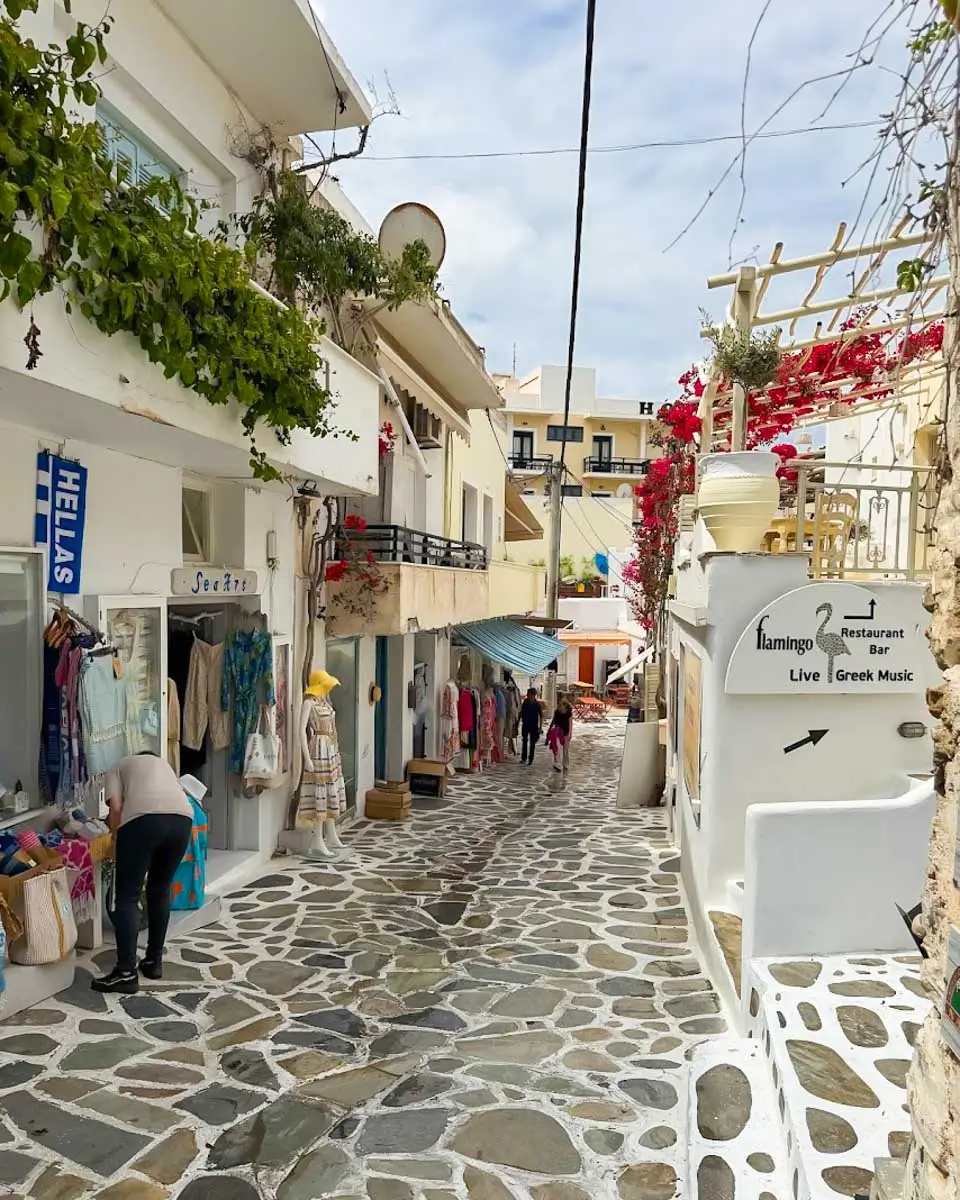 Pedestrian street lined with whitewashed buildings, shops, and cafes in Chora, Naxos
