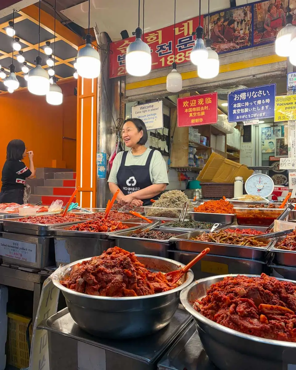 A-woman-at-a-stall-selling-goods-on-a-food-tour-in-Namdaemun Market-Seoul-South-Korea