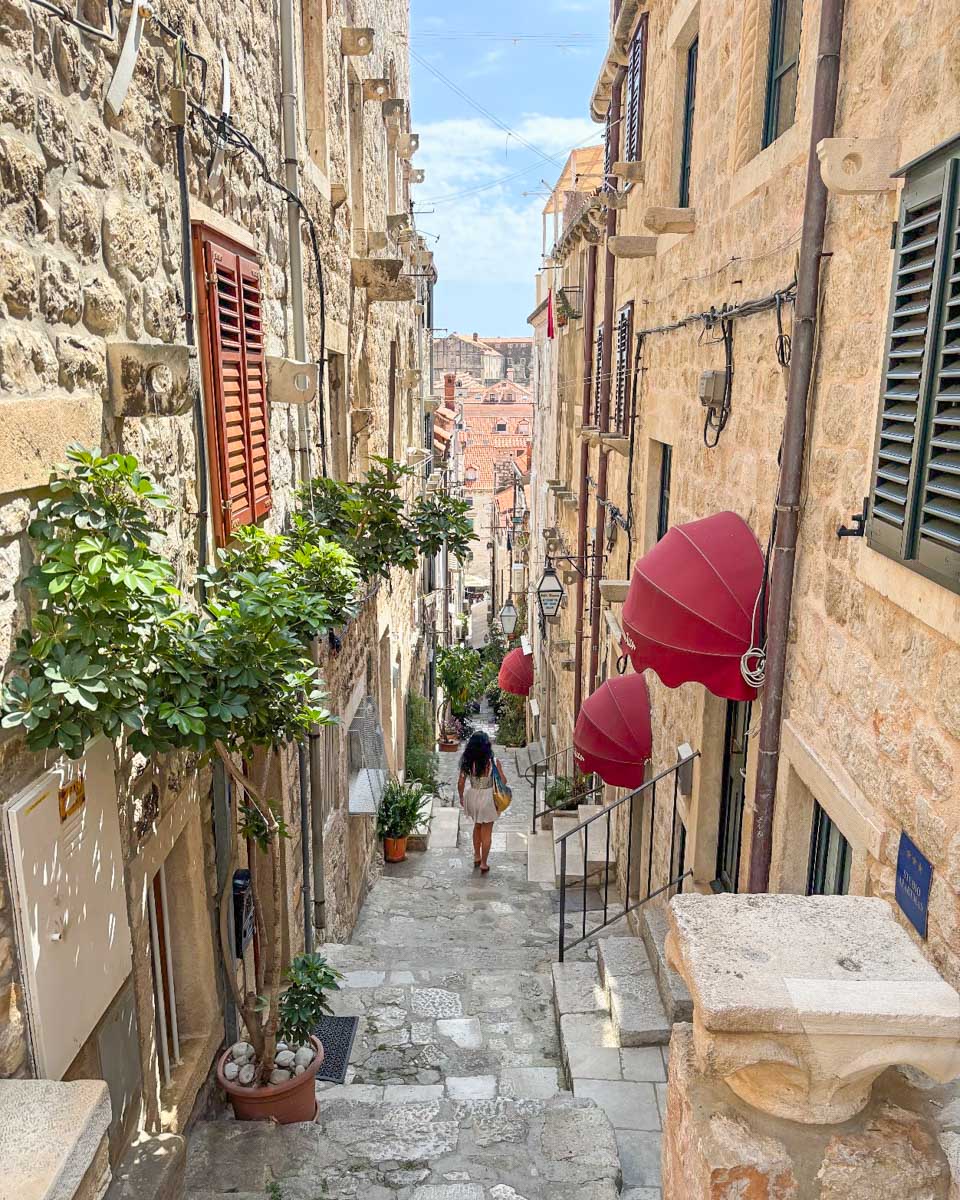 A woman walks down a side street in Dubrovnik
