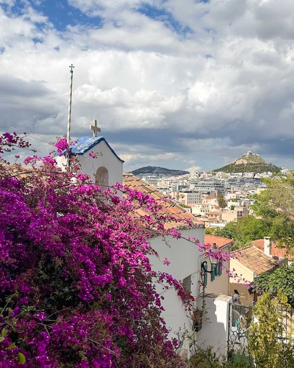 White chapel and bougainvillea overlooking the Anafiotika neighborhood in Athens, Greece