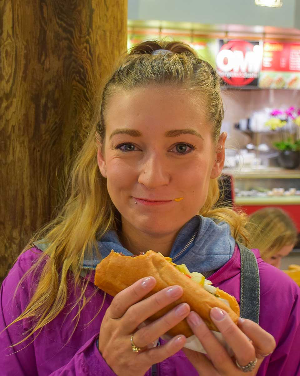 Bailey-eats-a-hotdog-on a food tour in Akureyri, Iceland
