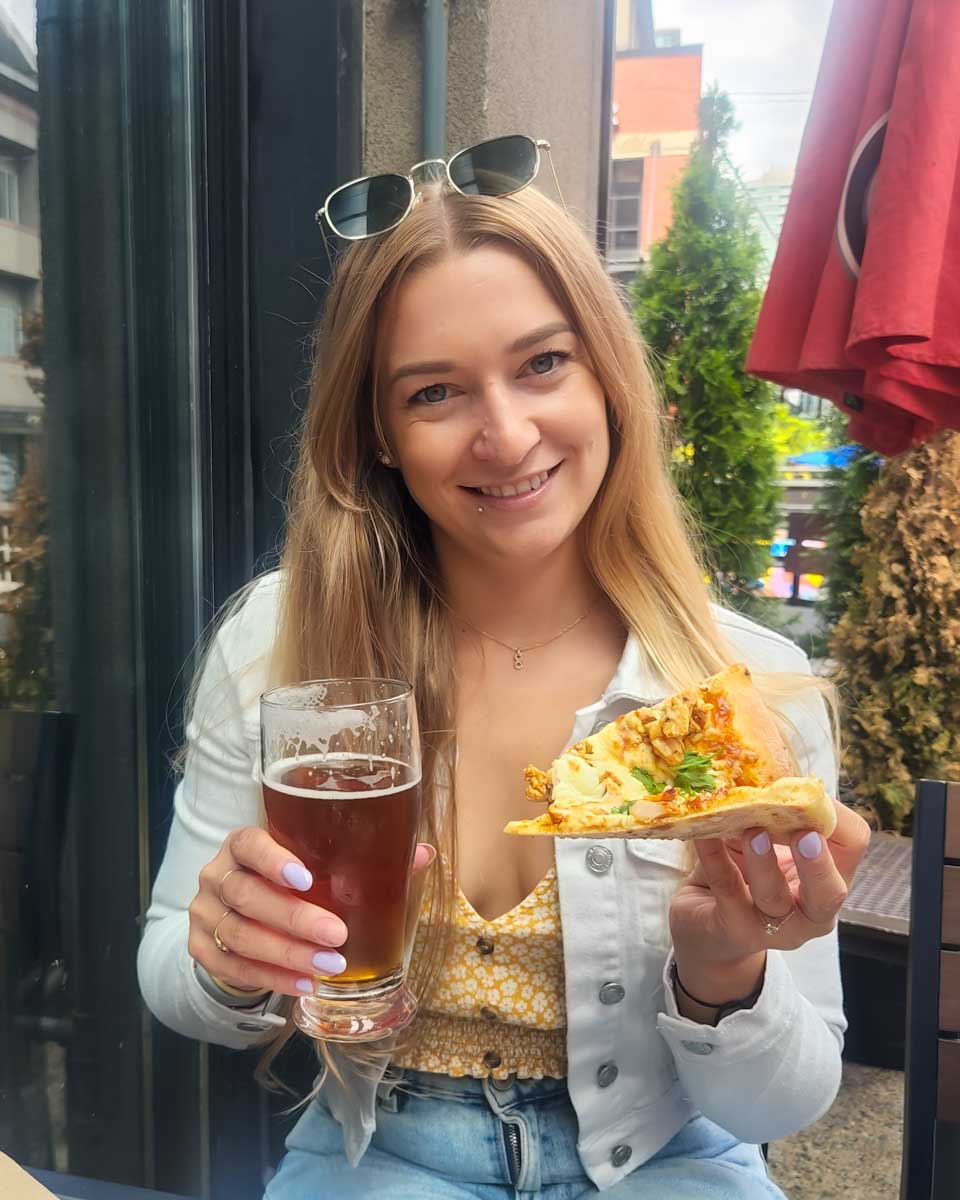 Bailey eats pizza and drinks beer on a food tour in Newport, Rhode Island