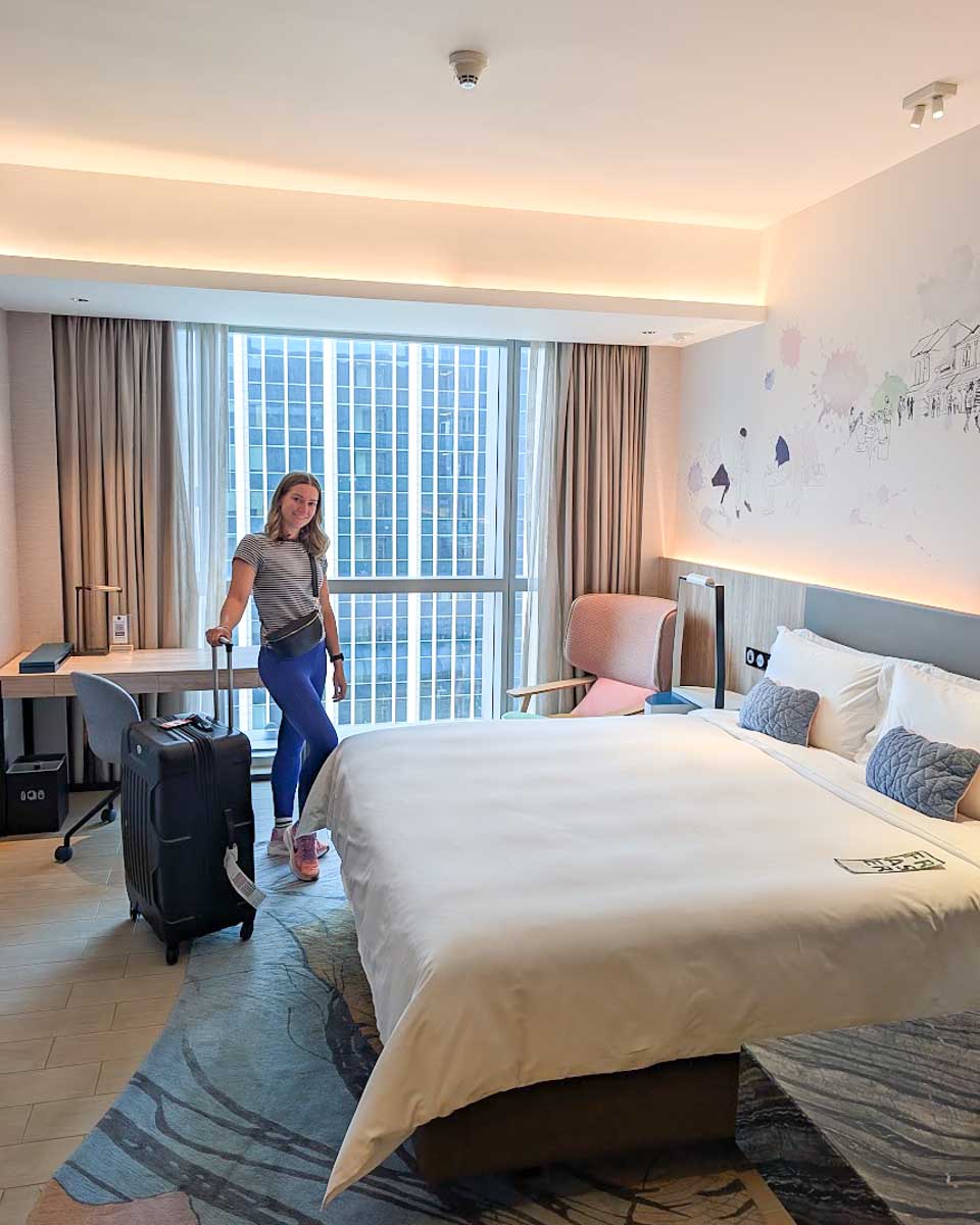 Bailey standing in the modern guest room at Capri by Fraser China Square Singapore