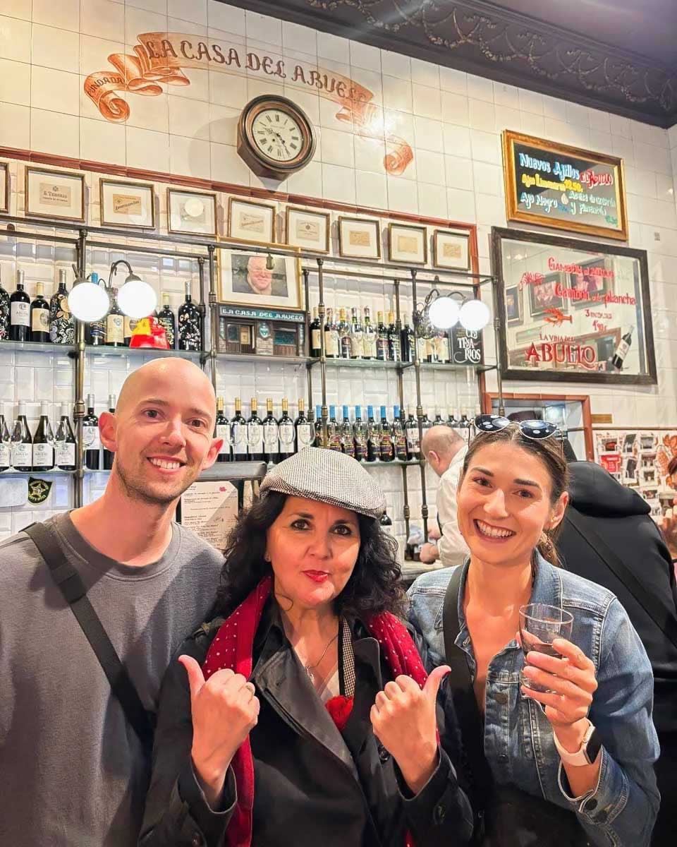 Brittni-and-Jesse-pose-with-their-tour-guide-on-a-tapas-tour-in-Madrid