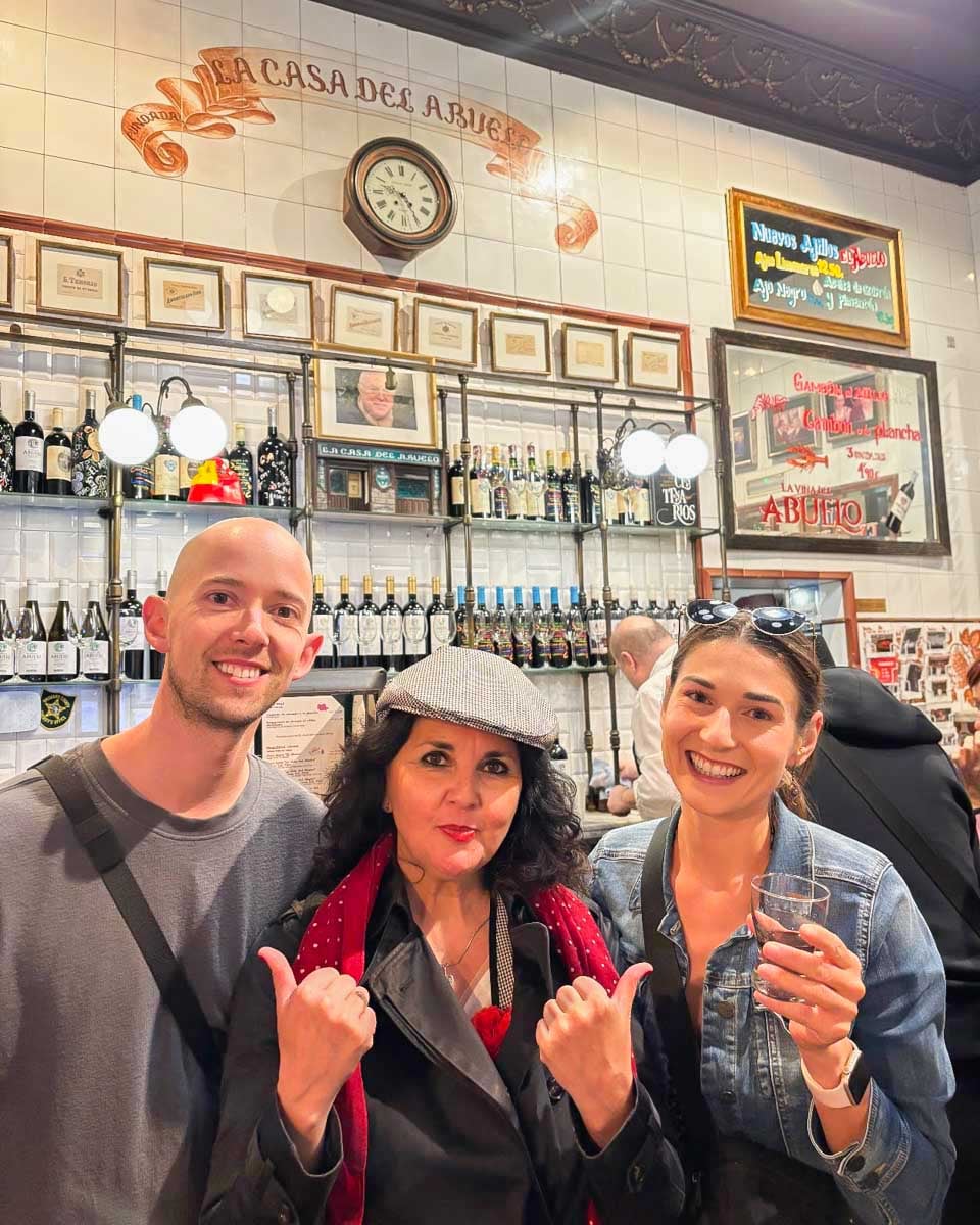 Brittni-and-Jesse-pose-with-their-tour-guide-on-a-tapas-tour-in-Madrid
