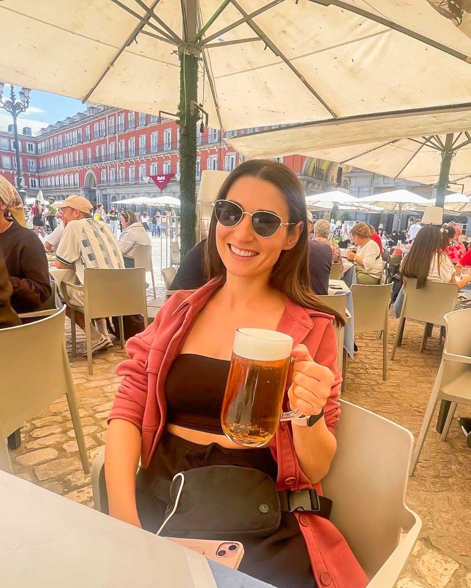 Brittni-drinks-a-beer-on-a-patio-in-Plaza-Mayor-Madrid