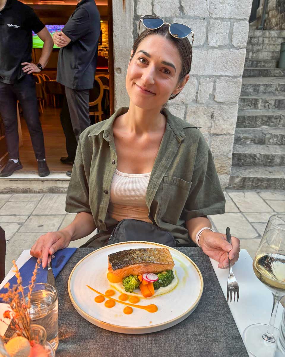 Brittni eats salmon for dinner at Dalmatino Dubrovnik restaurant