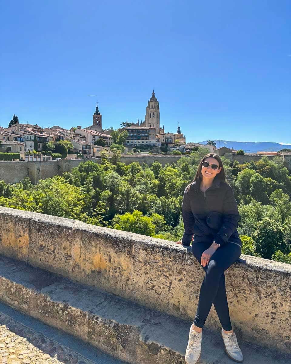 Brittni-poses-for-a-photo-in-Segovia-with-the-cathedral-in-the-background