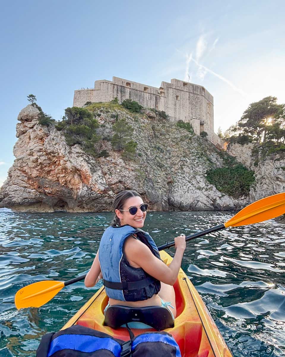 Brittni smiles while kayaking in front of Fort Lovrjenac in Dubrovnik