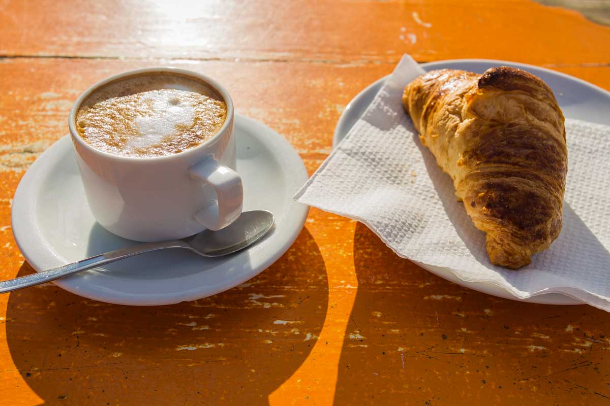 Cappuccino-with-croissant-for-breakfast-in-Pompeii Italy