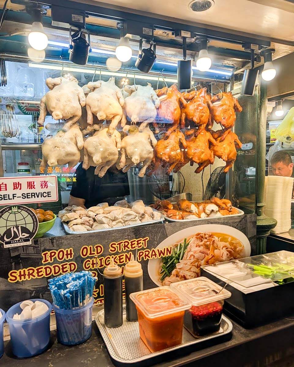 Roasted chickens hanging at a food stall during a Singapore food tour