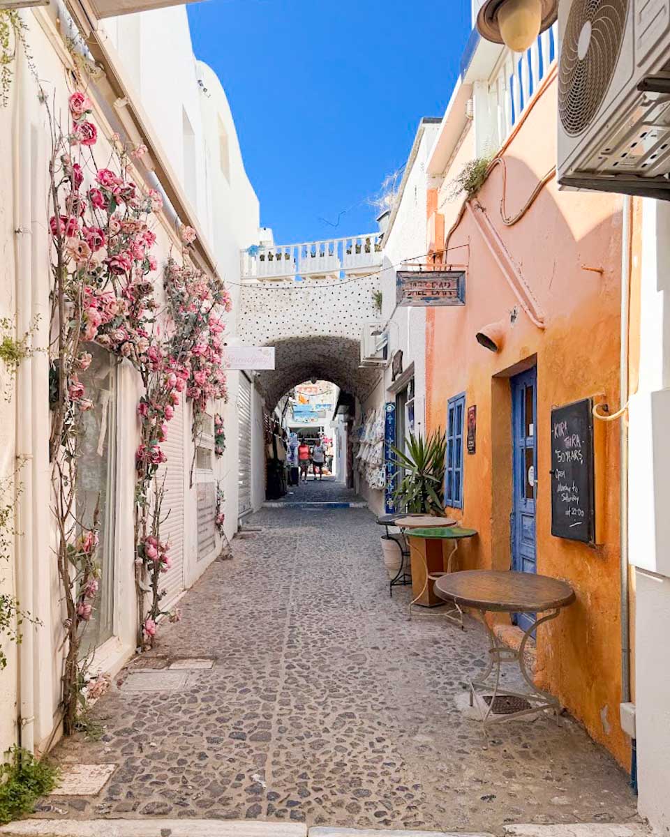 A colorful street lined with shops and buildings in Fira
