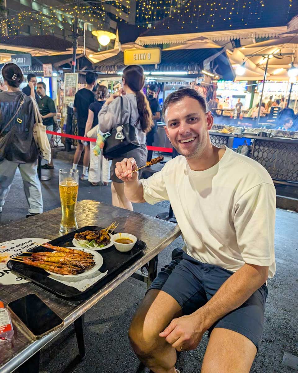 Daniel enjoying satay at Lau Pa Sat hawker centre in Singapore