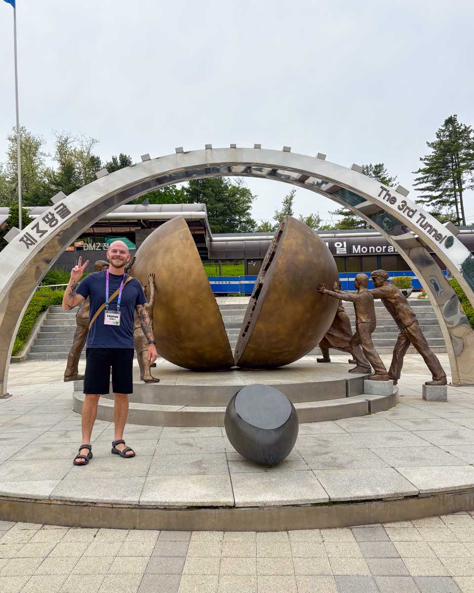 Evan stands at a monument for the reunification of Korea at the 3rd Infiltration Tunnel on a DMZ tour from Seoul South Korea 2