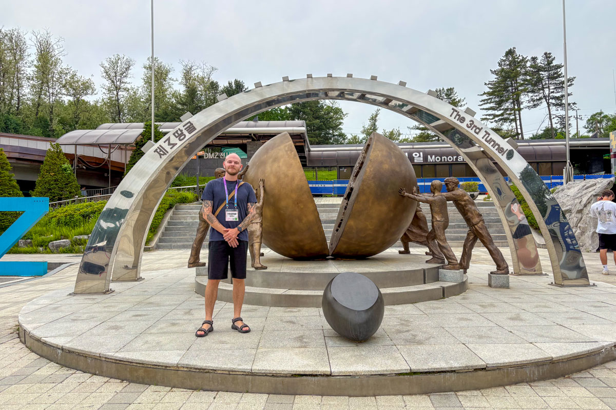 Evan stands at a monument for the reunification of Korea at the 3rd Infiltration Tunnel on a DMZ tour from Seoul South Korea 5