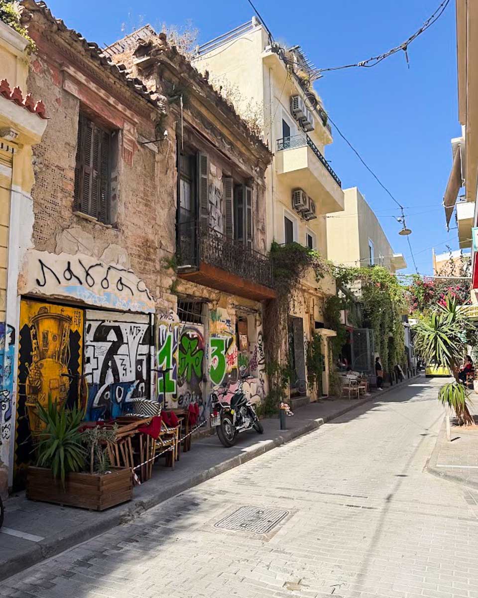 A quiet street in Psyrri with colorful graffiti and old buildings