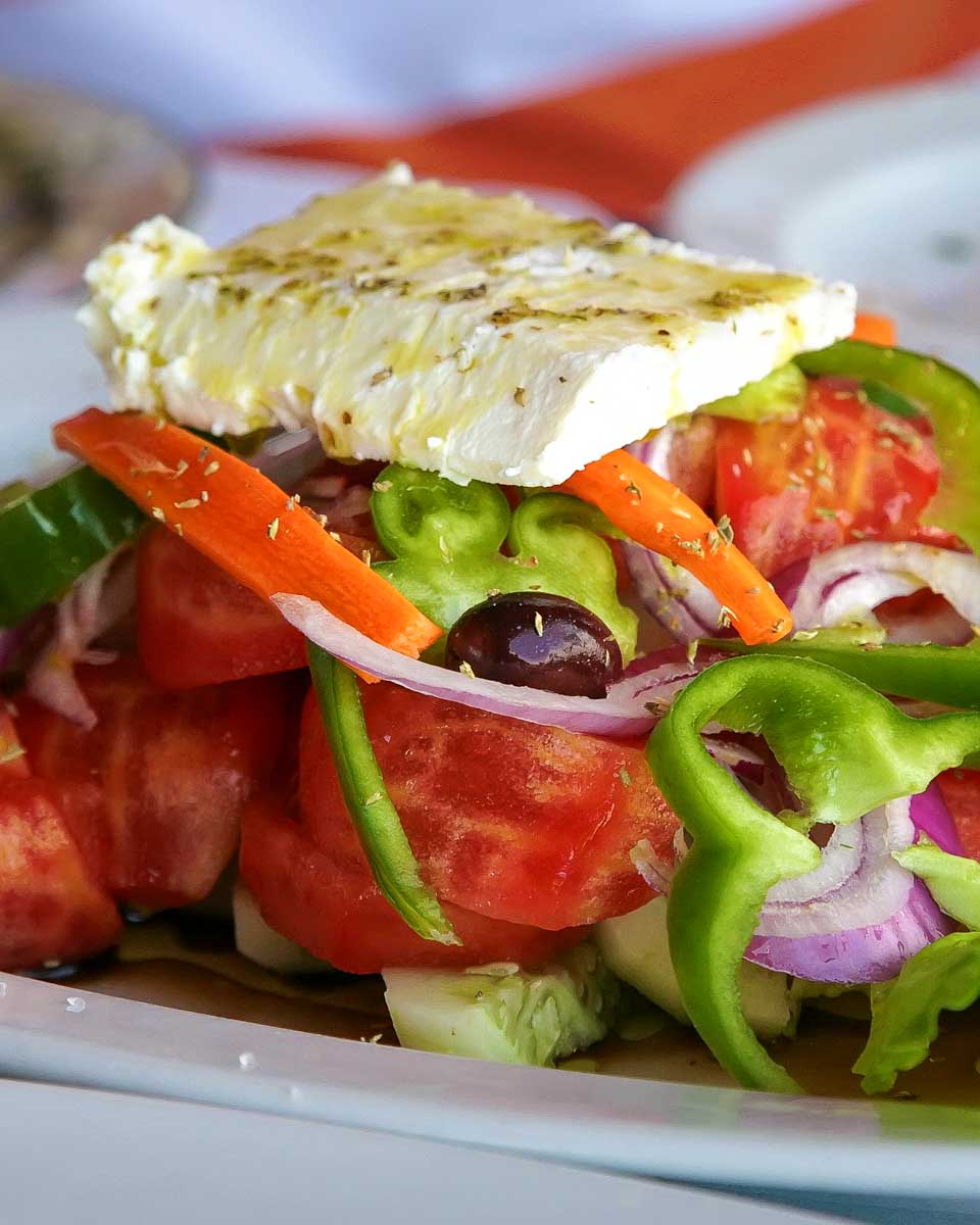 Traditional Greek salad with tomatoes, cucumber, green peppers, red onion, olives, and feta cheese prepared during an Athens cooking tour.