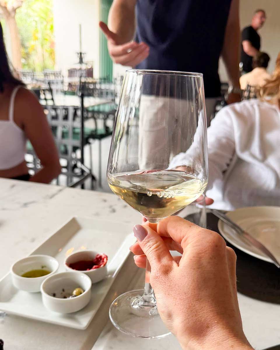 Hannah drinks wine at a cooking class in Santorini