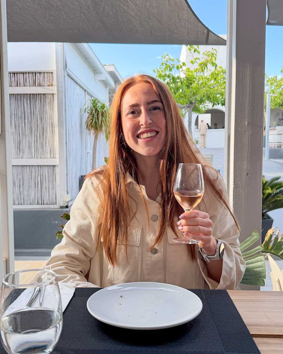 Hannah drinks wine in Santorini