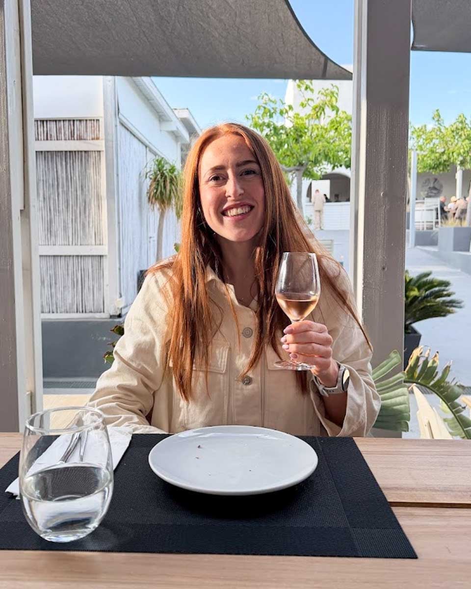 Hannah holding a glass of wine during a cooking class in Athens, Greece