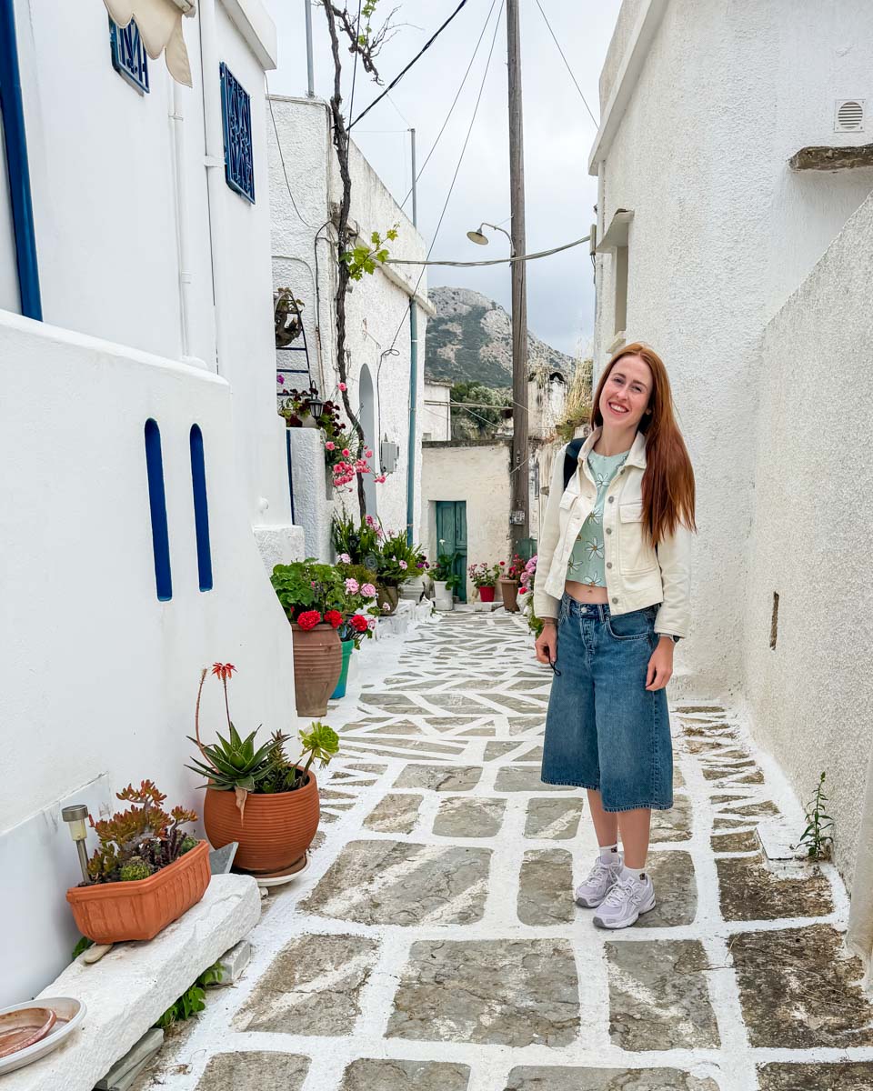 Hannah on the street between the whitewashed buildings of Naxos Greece