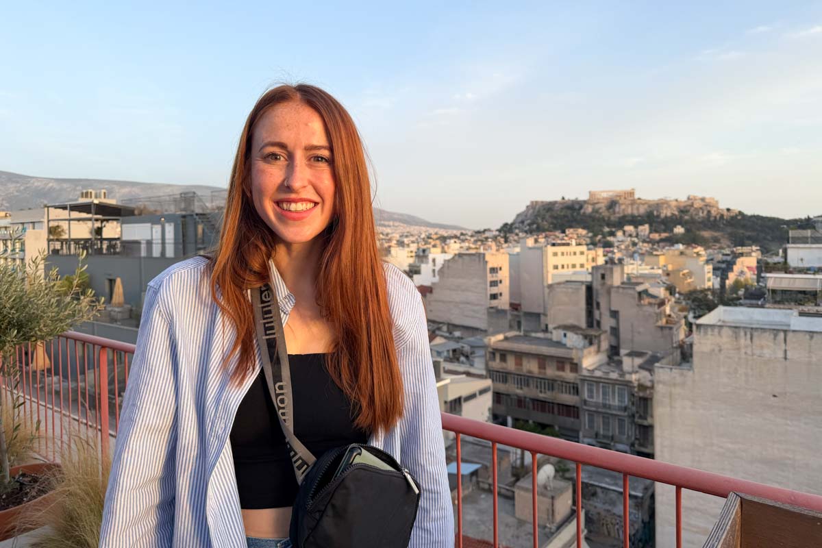 Hannah smiles at sunset with the Acropolis in the back in Athens Greece
