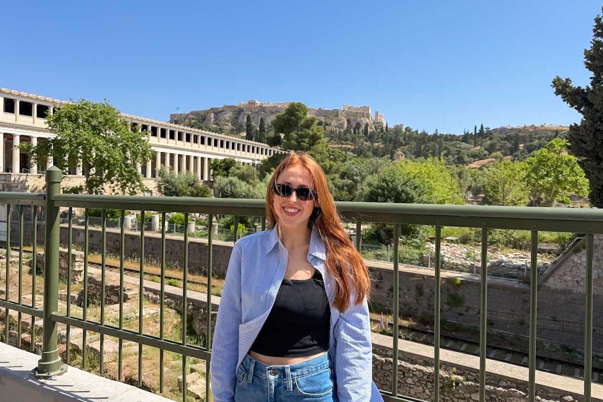 Hannah posing with the Ancient Agora and Acropolis behind her in Athens, Greece