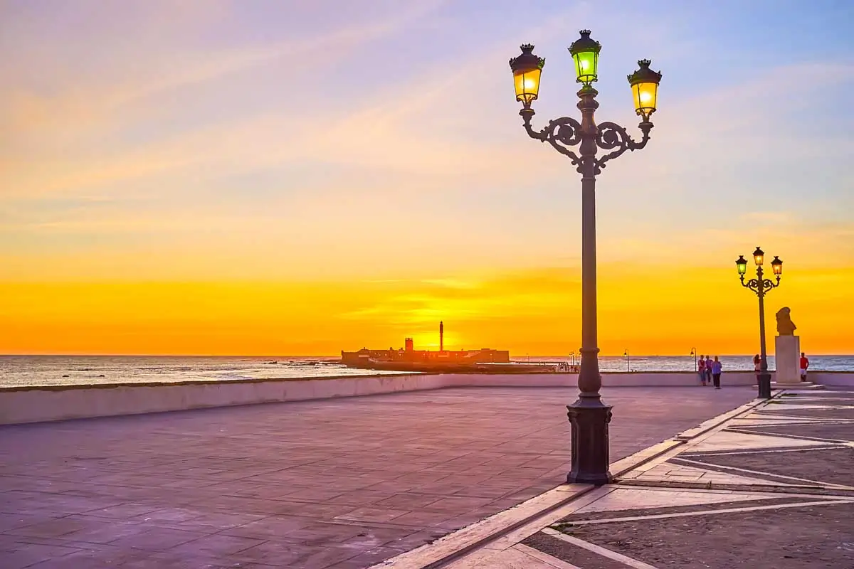 Paseo del Vendaval promenade and castillo de san sebastián at sunset in Cadiz Spain