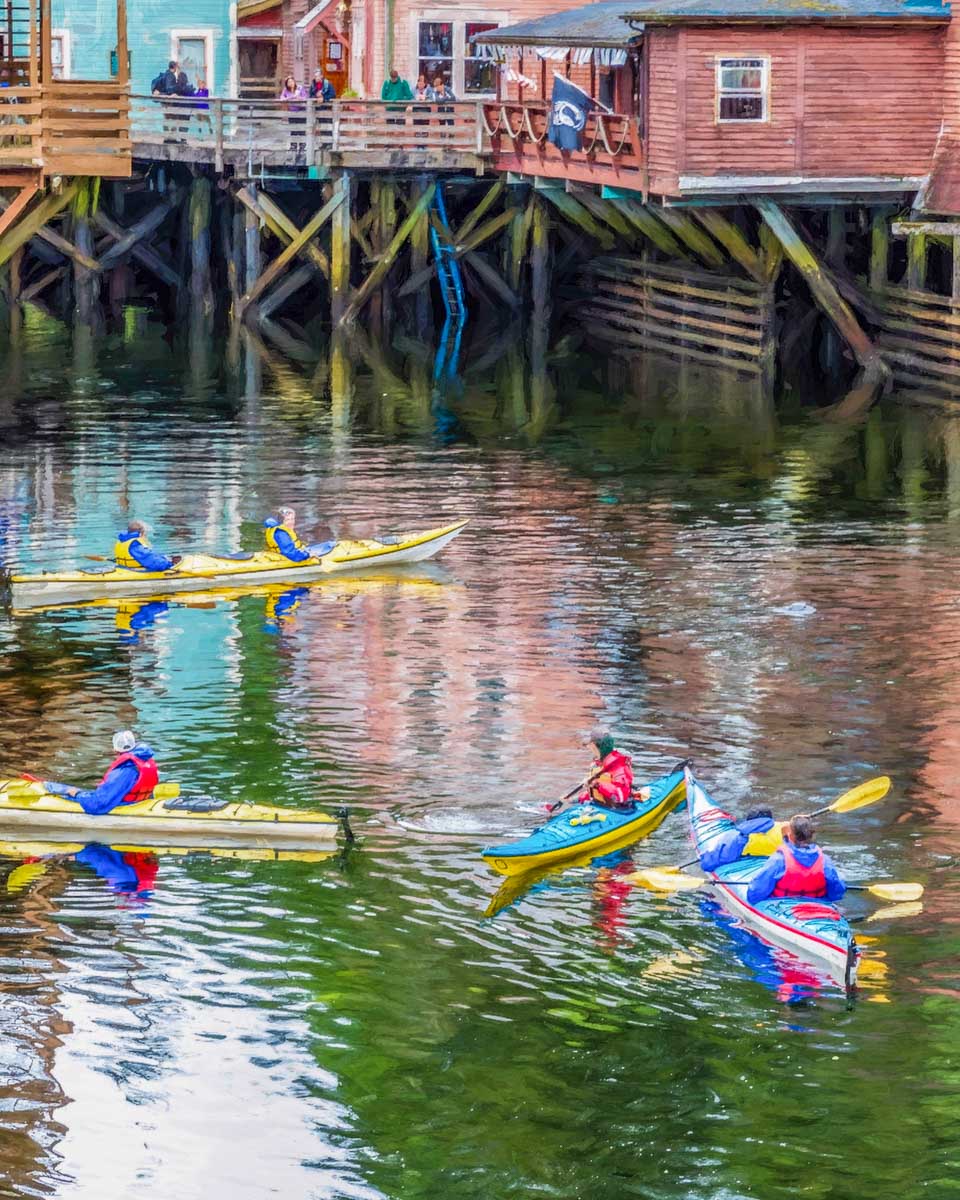 People kayak on Creek Street in Ketchikan Alaska