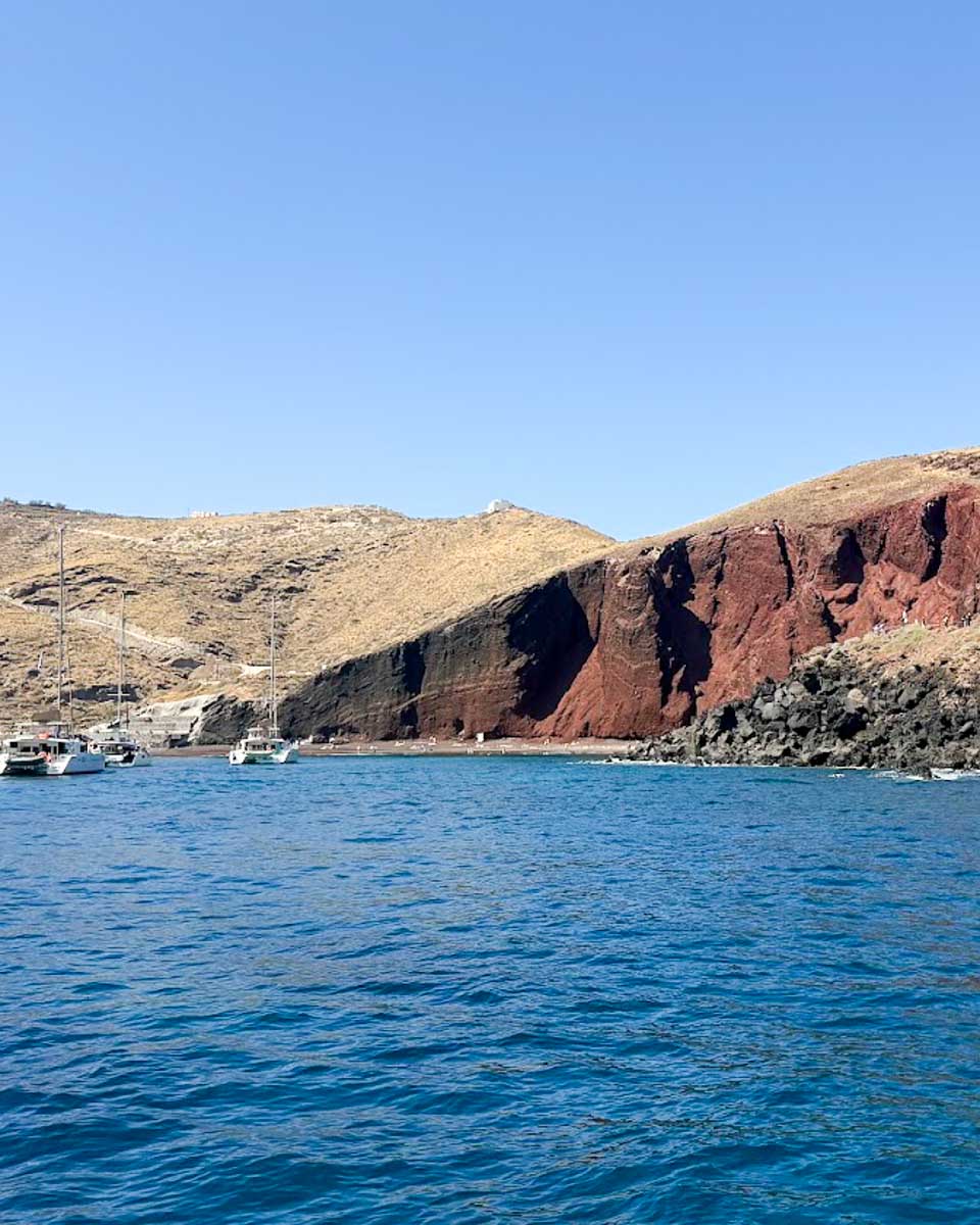 Red volcanic cliffs along the coastline near Red Beach in Santorini