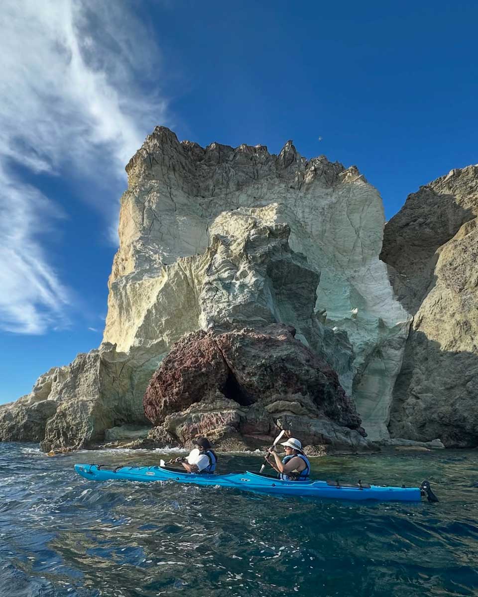 Two people kayak along the Santorini Coast