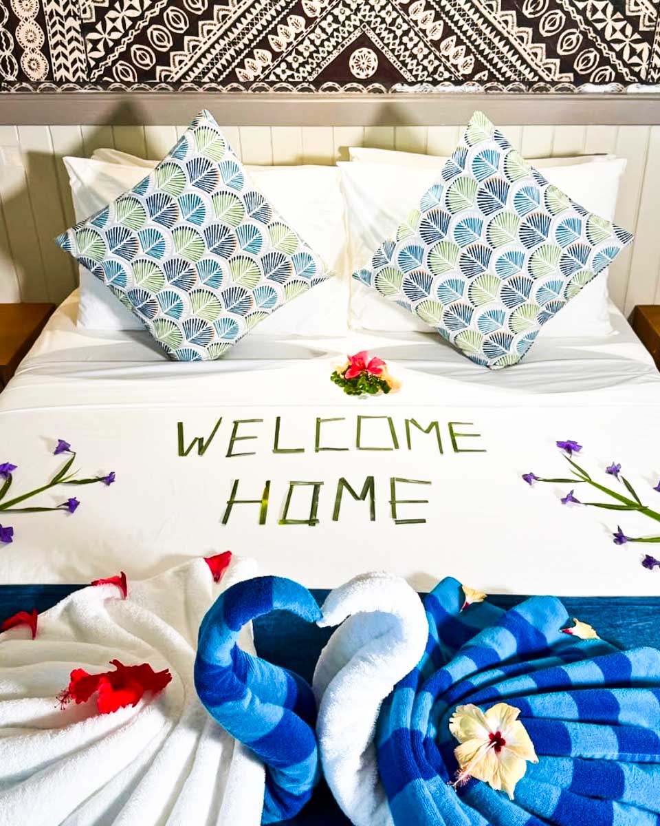 A bed that says Welcome Home on it at Plantation Island Resort in Fiji