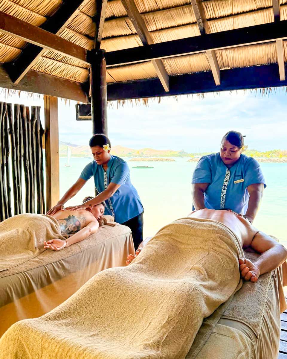 A couple receives an oceanfront massage at Plantation Island Resort in Fiji