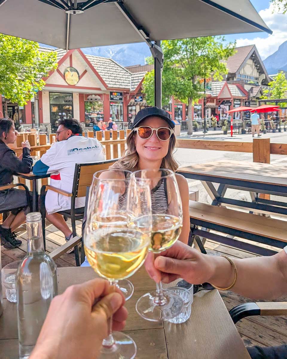Bailey cheers her glass of wine on Canmore Main Street
