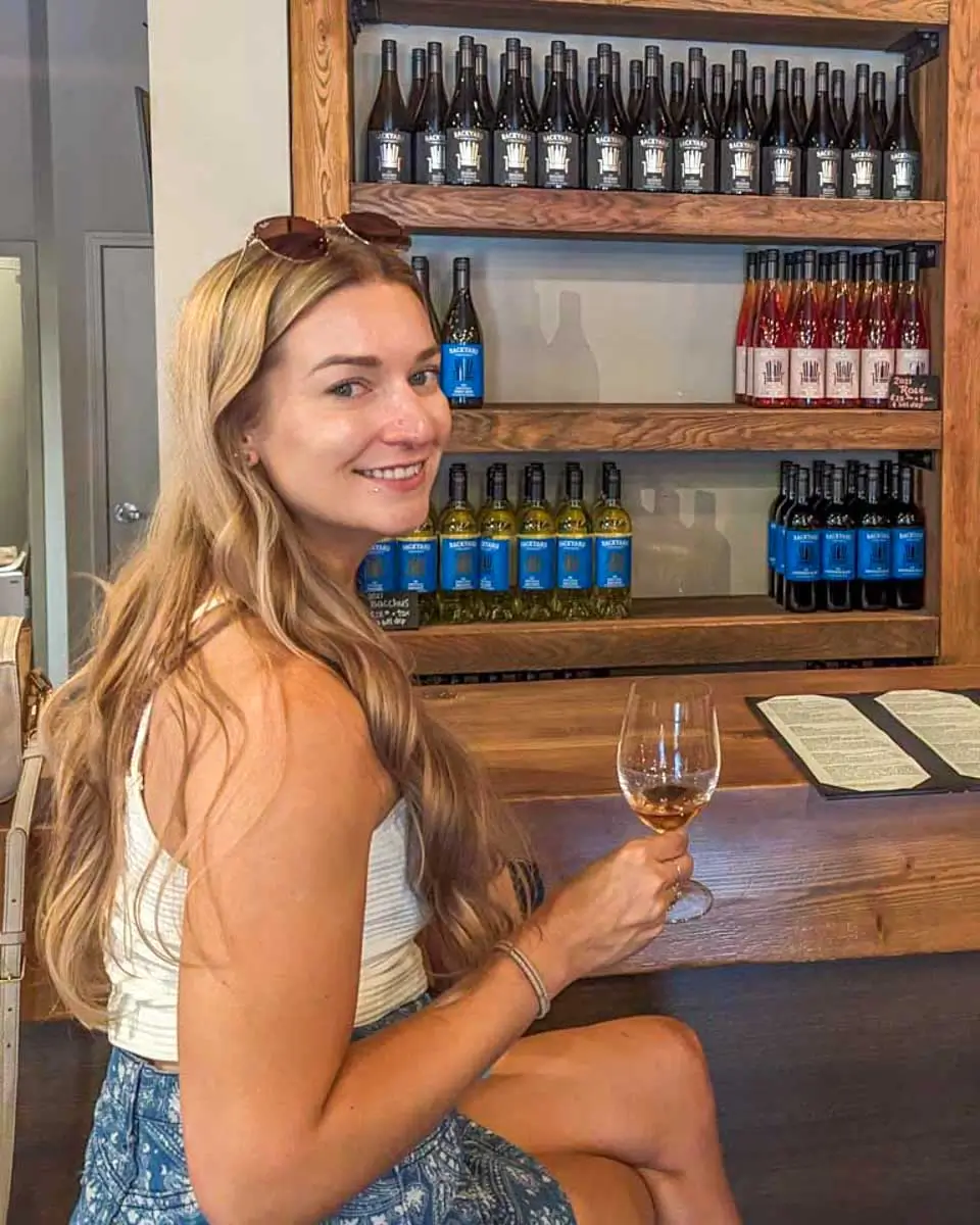 Bailey drinking wine on Island of Orleans on a tour from Quebec City