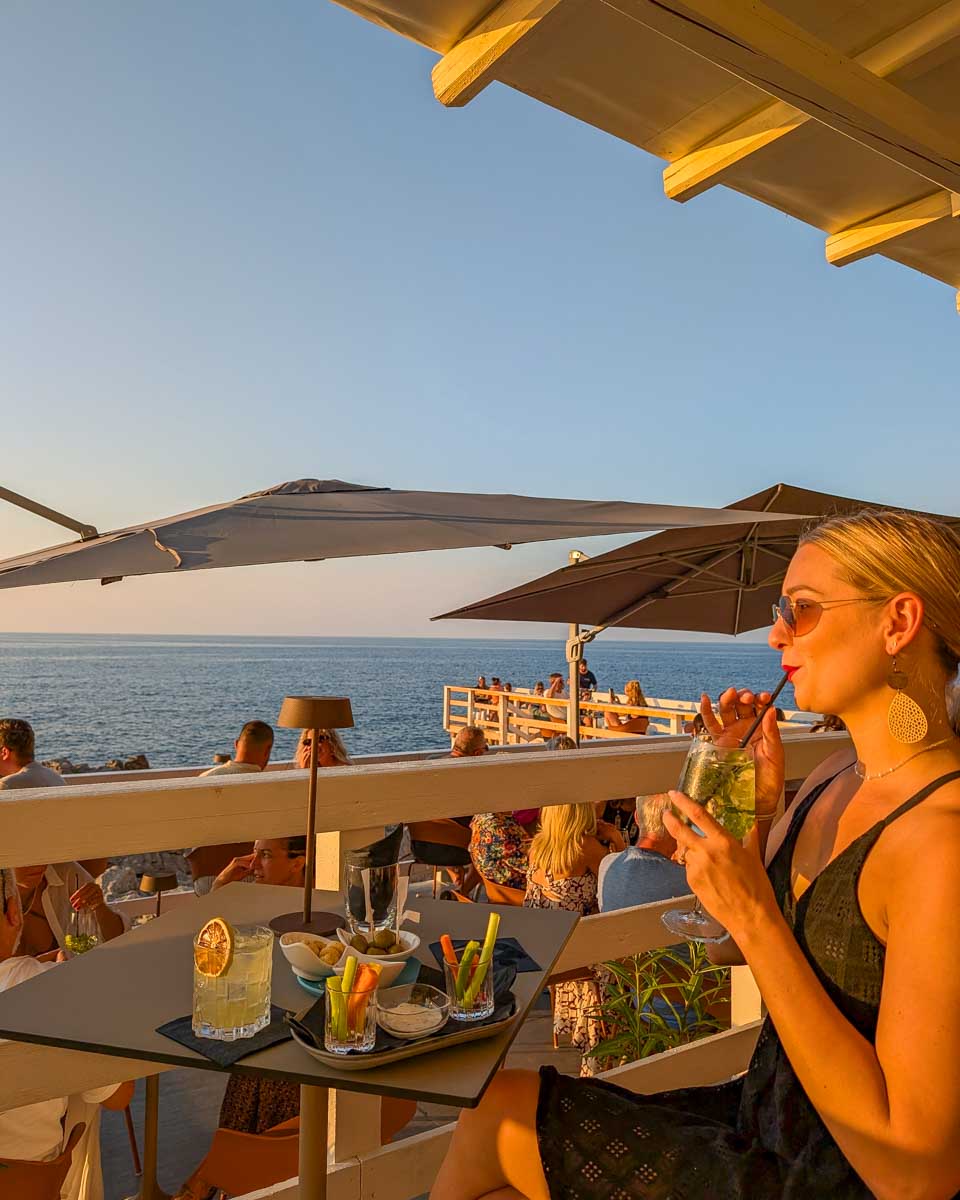 Bailey-drinks-aperitif-at-sunset-with-views-of-the-water-in Newport Beach, California