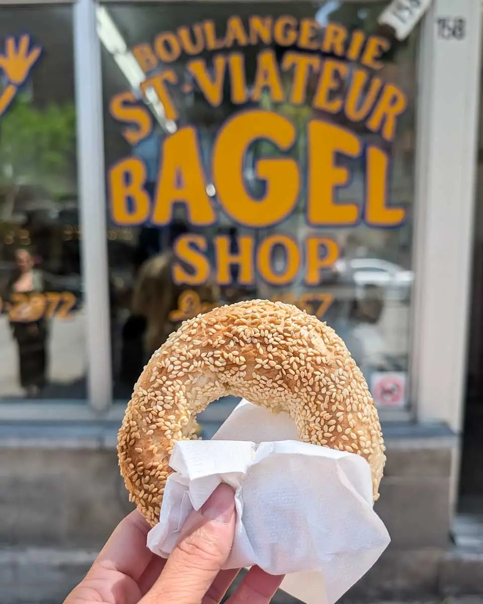 Bailey holding a bagel on a food tour in Montreal, Quebec