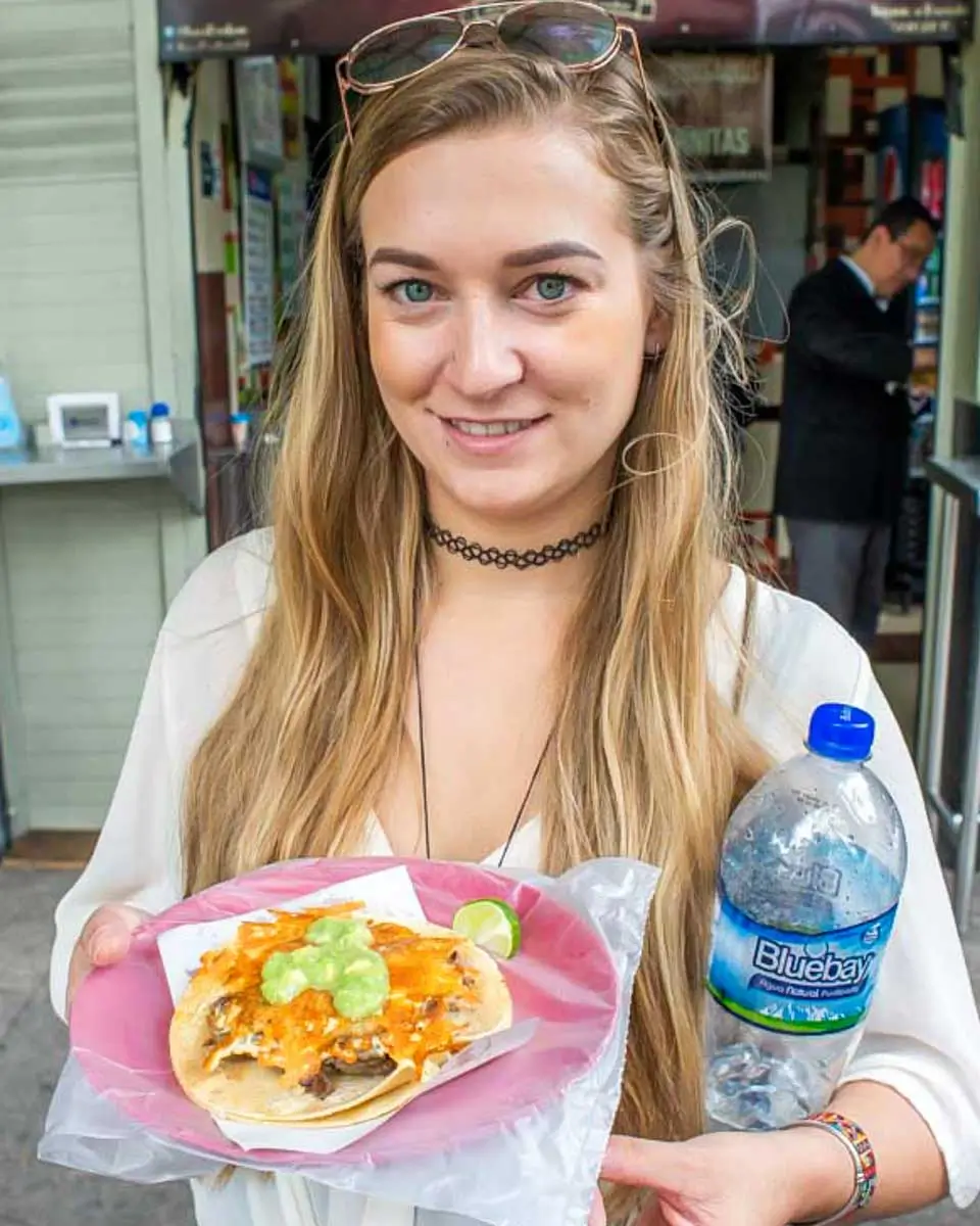 Bailey holding a plate of taco in Cozumel, Mexico
